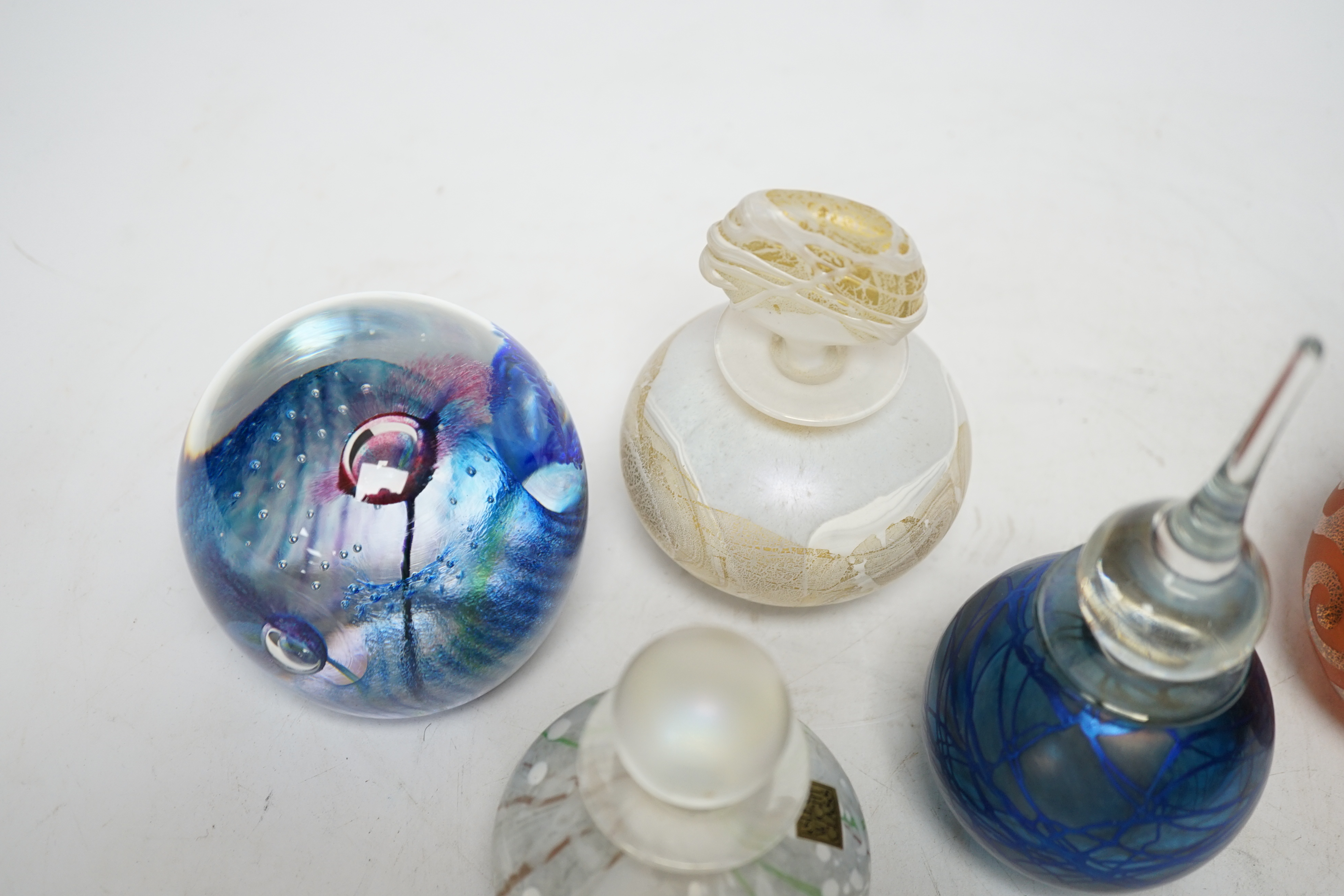 Four perfume bottles possibly by Blow Zone and paperweight by Helen Millard, tallest 17cm high